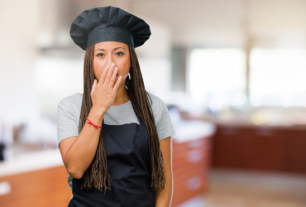 Retrato de una joven panadera negra que cubre la boca, símbolo de silencio y represión, tratando de no decir nada.