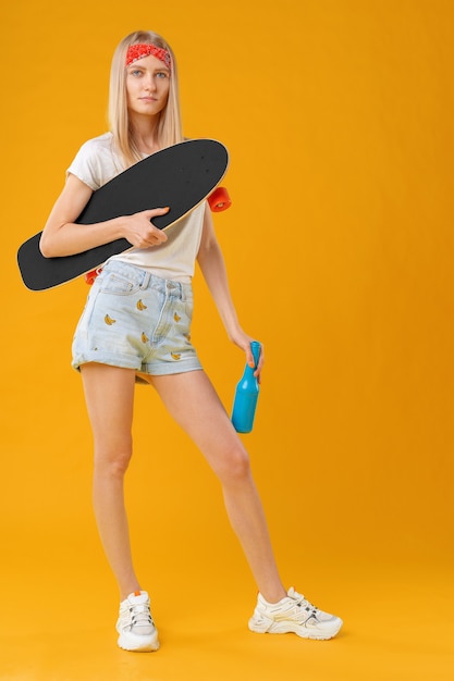 Retrato de una joven en pantalones cortos con longboard