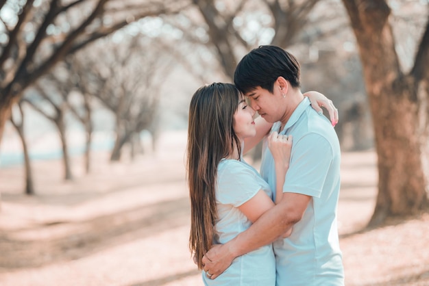 Retrato de una joven pareja asiática enamorada en el bosqueGente tailandesa feliz de estar juntosConcepto del día de San Valentín