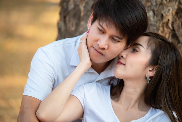 Retrato de una joven pareja asiática enamorada en el bosqueGente tailandesa feliz de estar juntosConcepto del día de San Valentín