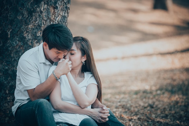 Retrato de una joven pareja asiática enamorada en el bosqueGente tailandesa feliz de estar juntosConcepto del día de San Valentín