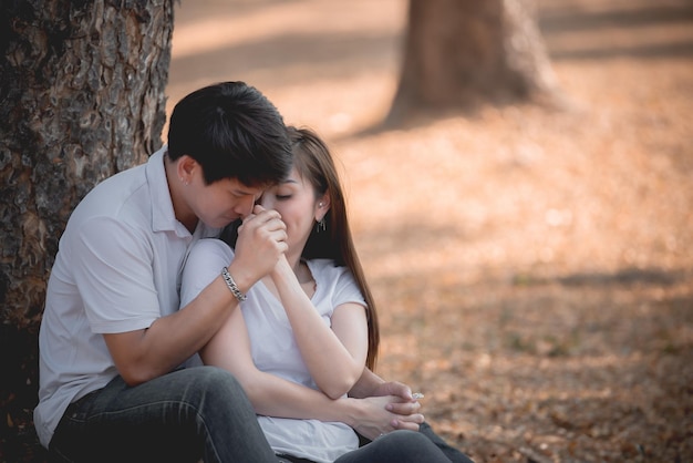 Retrato de una joven pareja asiática enamorada en el bosqueGente tailandesa feliz de estar juntosConcepto del día de San Valentín