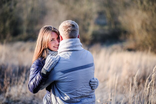 Retrato de joven pareja enamorada del oso de peluche en bosque de invierno