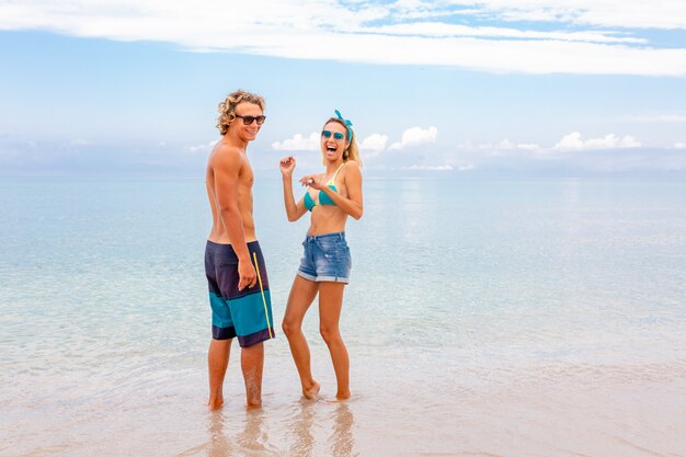 Retrato de joven pareja de enamorados abrazándose en la playa y disfrutando de estar juntos. Pareja joven divirtiéndose en una costa arenosa