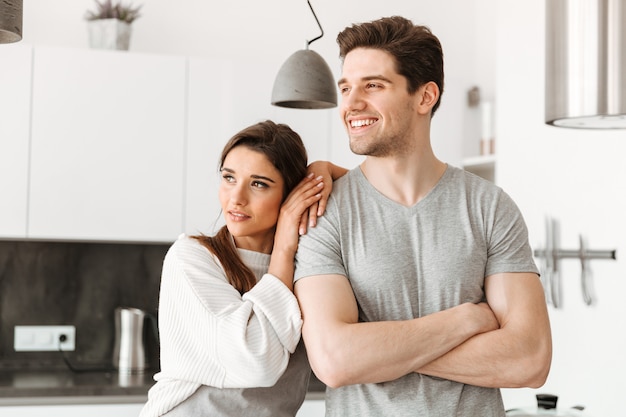 Retrato de una joven pareja feliz en la cocina