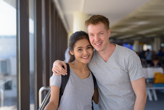 Retrato de joven pareja multiétnica disfrutando de vacaciones juntos