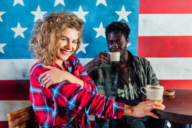 Foto retrato de una joven pareja relajándose juntos en una cafetería.