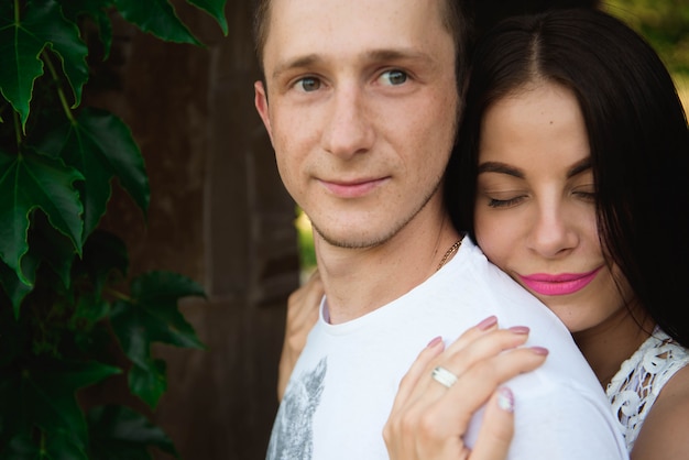 Retrato de la joven pareja romántica feliz que de pie en el abrazo al aire libre.