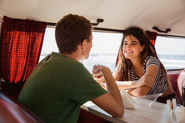 Retrato de joven pareja sonriente disfrutar viaje dentro minivan