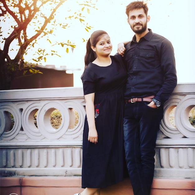 Foto retrato de una joven pareja sonriente de pie al aire libre