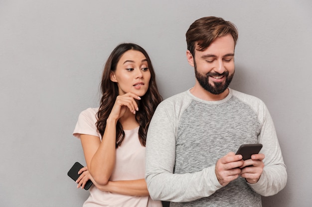 Retrato de una joven pareja con teléfonos móviles