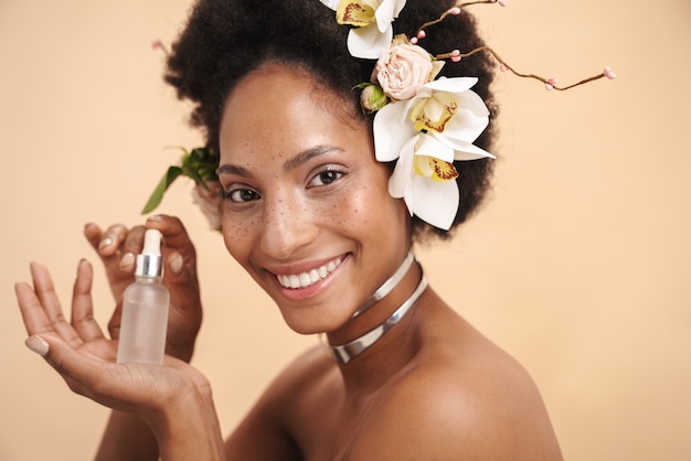 Retrato, de, joven, pecoso, mujer afroamericana, tenencia, facial, suero, crema, botella