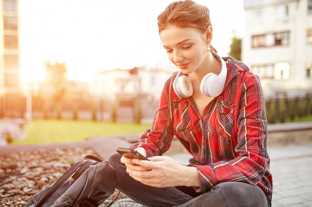 Retrato de una joven pelirroja que escucha música en auriculares