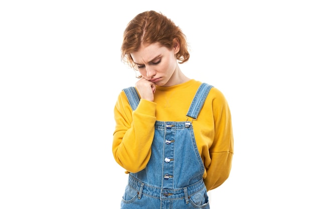 El retrato de una joven pelirroja tocándose la boca con la mano tiene dolor de muelas aislado en un estudio blanco backgroundxA