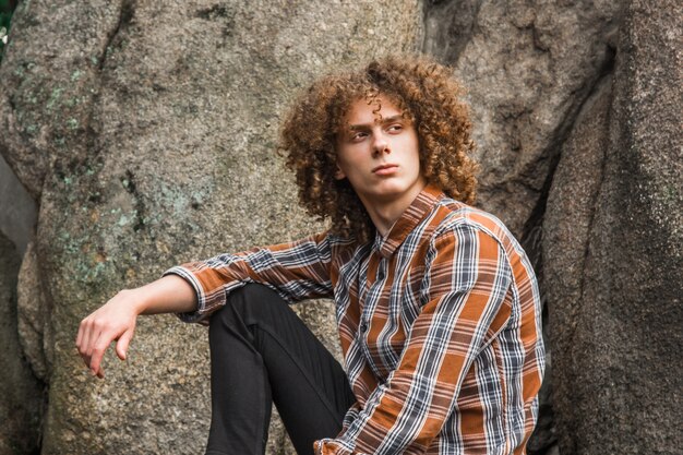 Retrato de un joven de pelo rizado entre las piedras