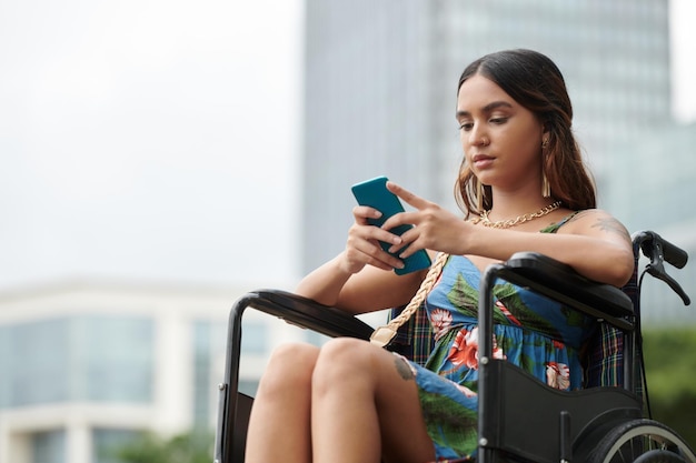 Retrato de una joven pensativa leyendo una notificación o un mensaje de texto en un teléfono inteligente
