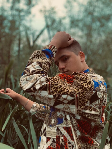 Foto retrato de un joven de pie en el bosque