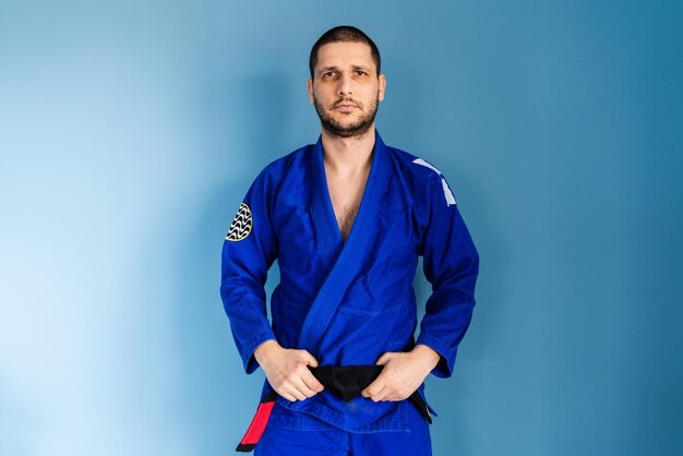 Foto retrato de un joven de pie contra un fondo azul