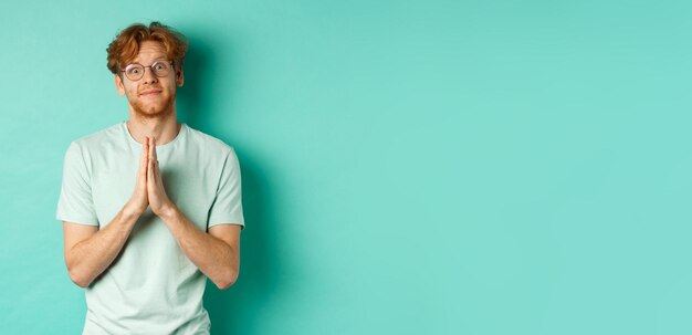 Retrato de un joven de pie contra un fondo azul