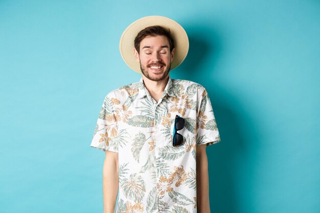 Foto retrato de un joven de pie contra un fondo azul