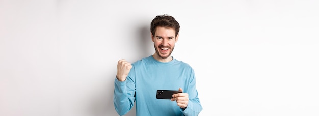 Foto retrato de un joven de pie contra un fondo blanco