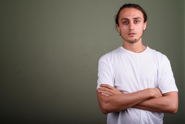 Foto retrato de un joven de pie contra un fondo gris