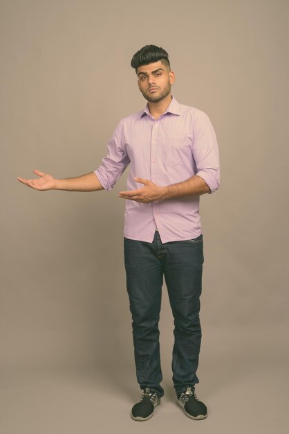 Foto retrato de un joven de pie contra un fondo gris