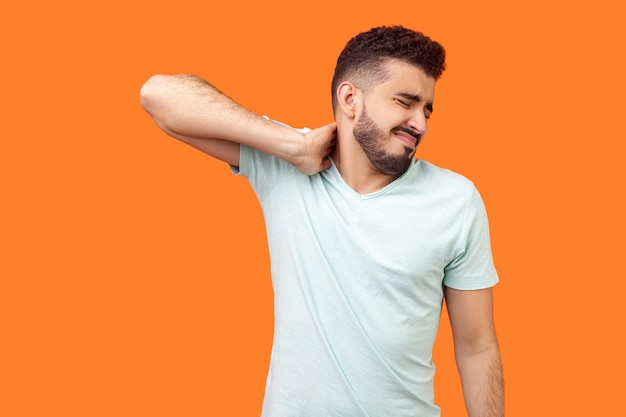 Retrato de un joven de pie contra un fondo naranja