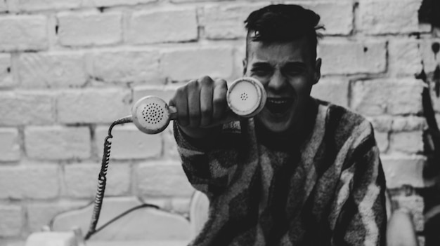 Retrato de un joven de pie contra la pared actuando