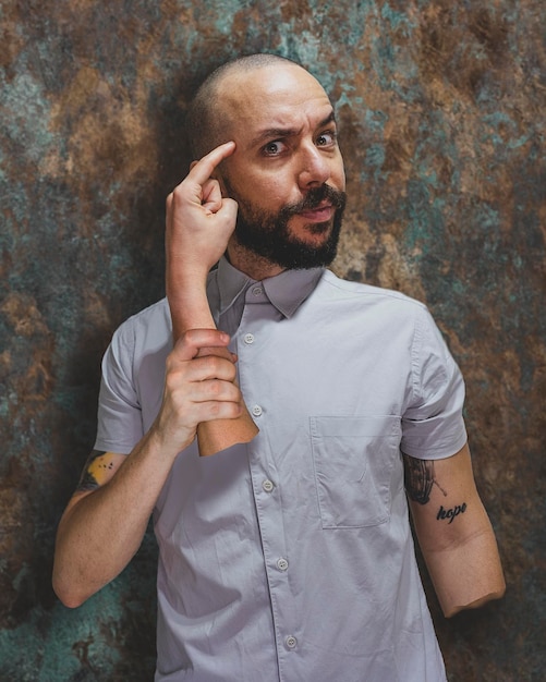 Foto retrato de un joven de pie contra la pared