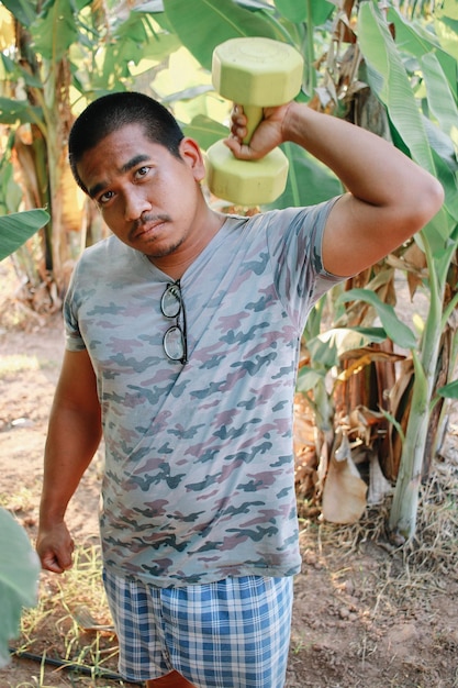 Foto retrato de un joven de pie contra las plantas