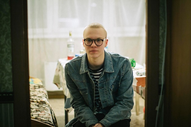 Retrato de un joven de pie junto a la ventana