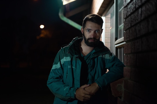 Foto retrato de un joven de pie por la noche