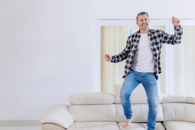 Foto retrato de un joven de pie en el sofá en casa