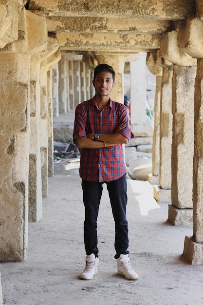 Foto retrato de un joven de pie en un viejo corredor