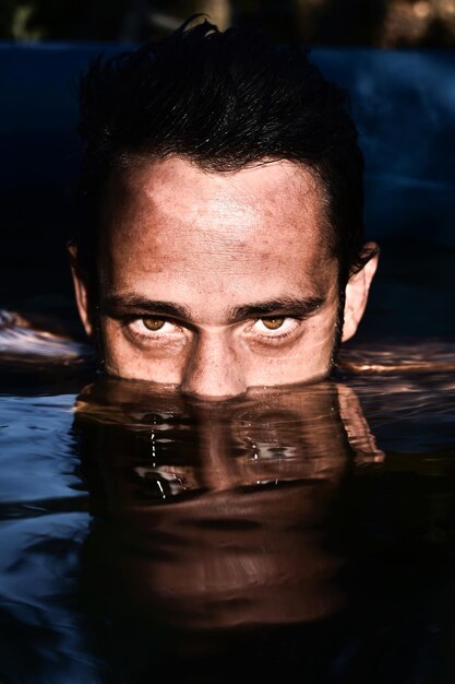 Foto retrato de un joven en una piscina