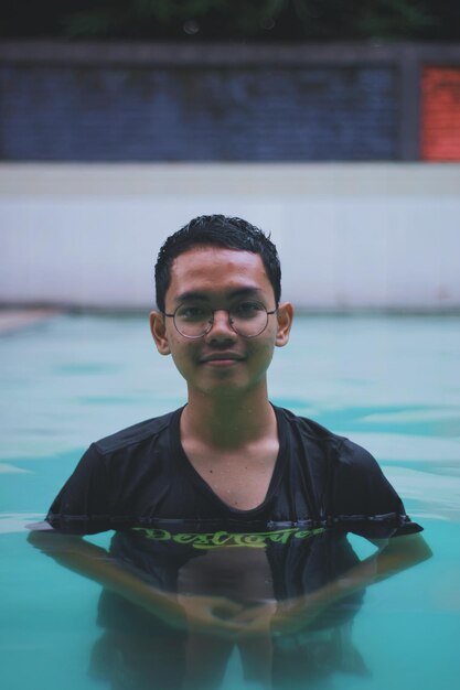 Foto retrato de un joven en una piscina