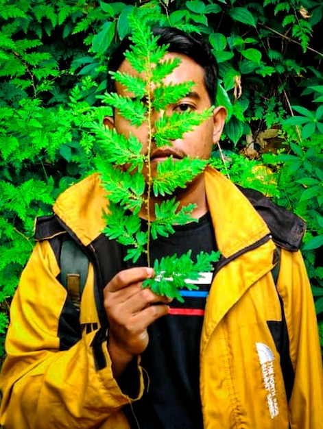 Foto retrato de un joven con plantas amarillas