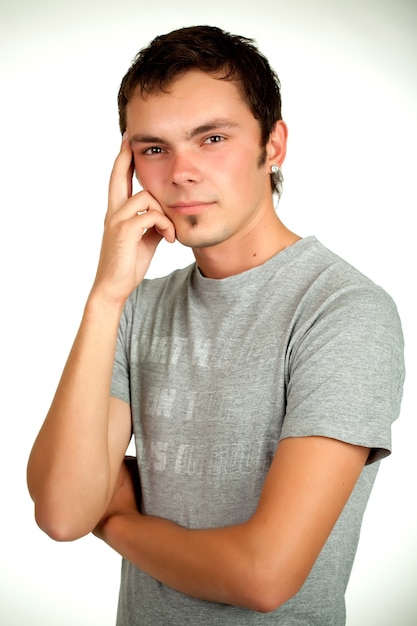 Retrato de un joven positivo caucásico en una camisa gris y jeans