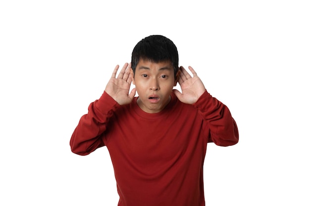 Retrato de un joven que entrega la oreja escuchando y escuchando rumores o chismes en un estudio aislado en un espacio de copia de fondo blanco