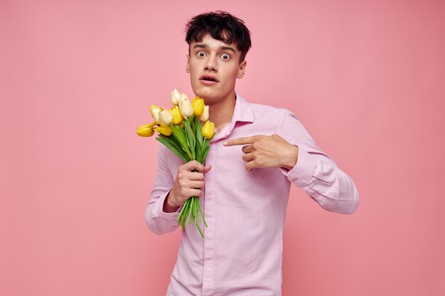 Retrato de un joven ramo de flores fecha romance posando fondo rosa inalterado