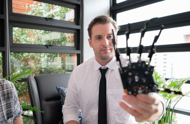 Foto retrato de un joven con un robot en las manos