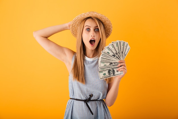 Retrato de una joven rubia emocionada con sombrero de verano