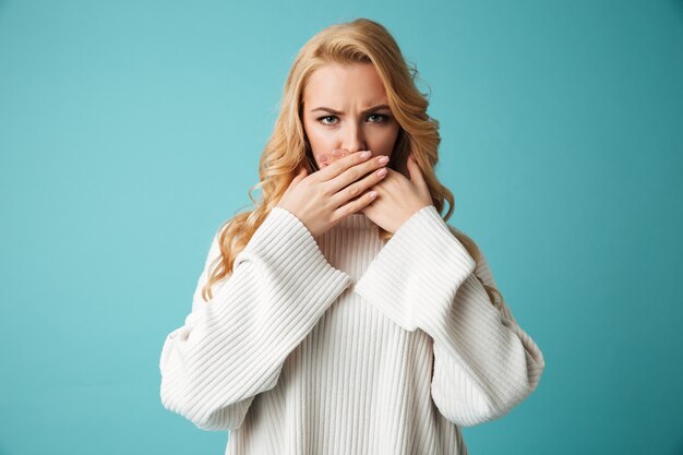 Retrato de una joven rubia enojada en suéter