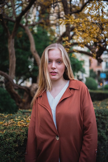 Retrato de una joven rubia posando y mirando a la cámara Lleva un abrigo en la ciudad