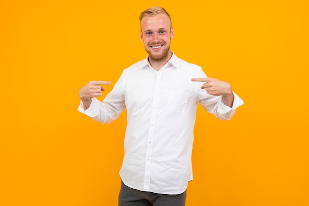 Retrato de un joven rubio con una camisa blanca se muestra con un diseño en amarillo con espacio de copia