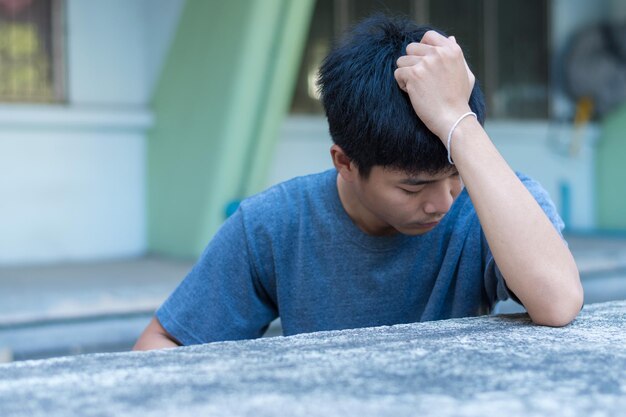 Foto retrato de un joven sentado al aire libre