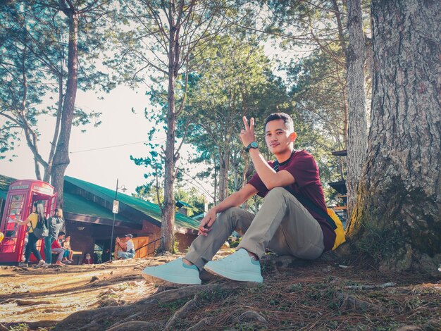 Foto retrato de un joven sentado en el campo