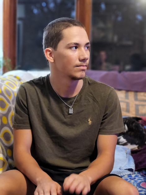 Foto retrato de un joven sentado en casa