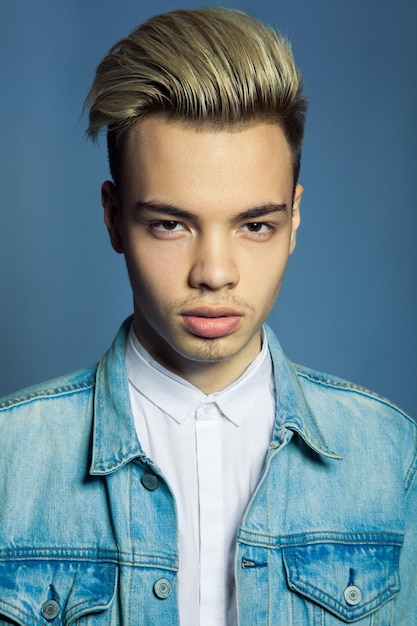 Foto retrato de un joven serio contra un fondo azul